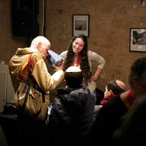 Bright, expressive culture scene with diverse group sharing a joyful moment in an indoor setting at night.